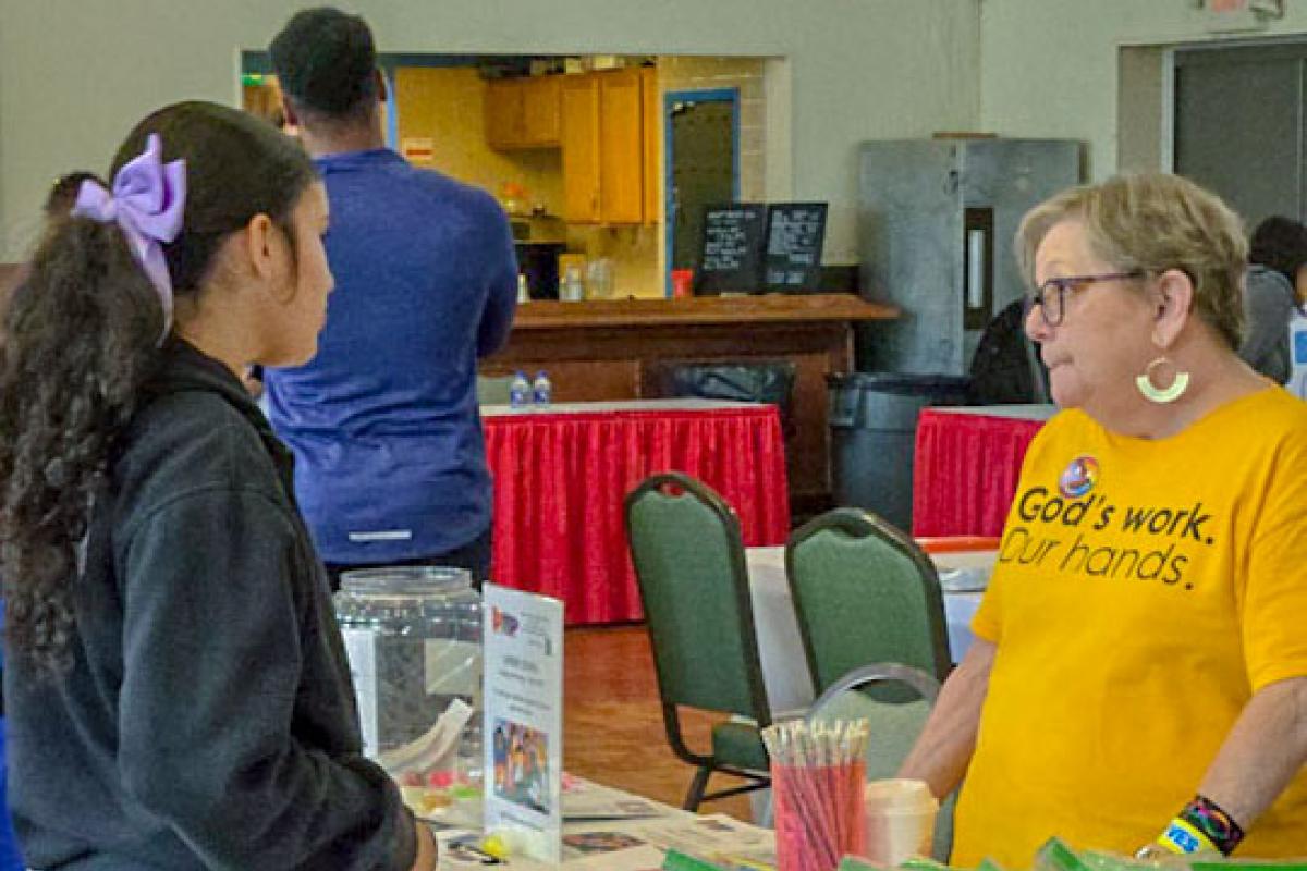 Health Fair exhibitor explains service to participant of the 10th Annual Health Fair  - Image